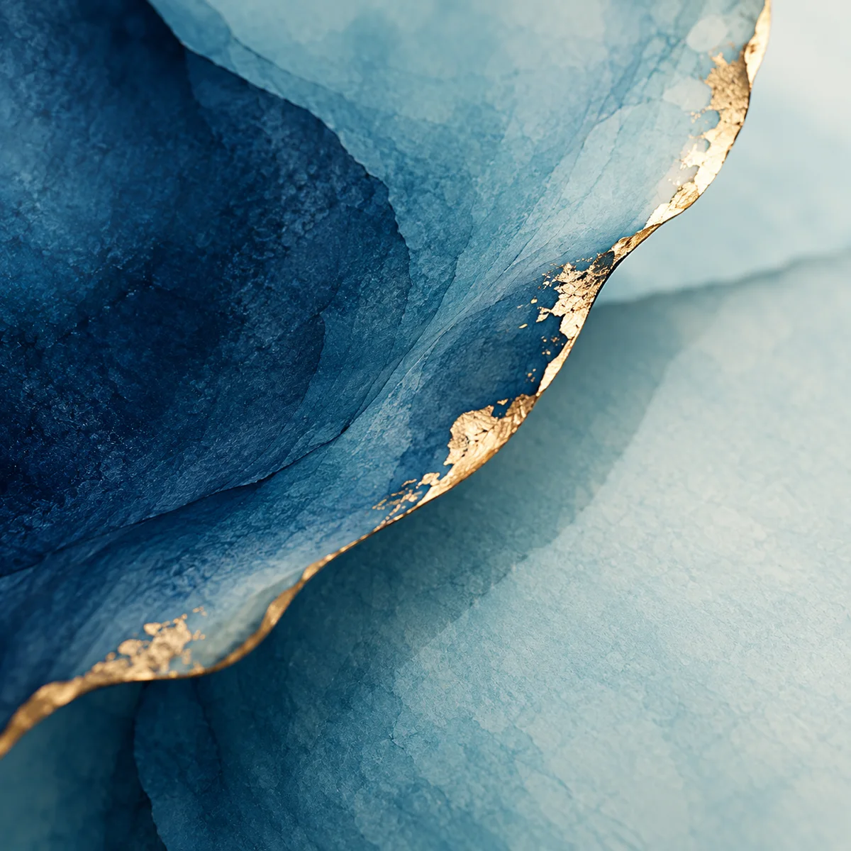 Close view of blue pigment with sparse irregular gold leaf at the edges.