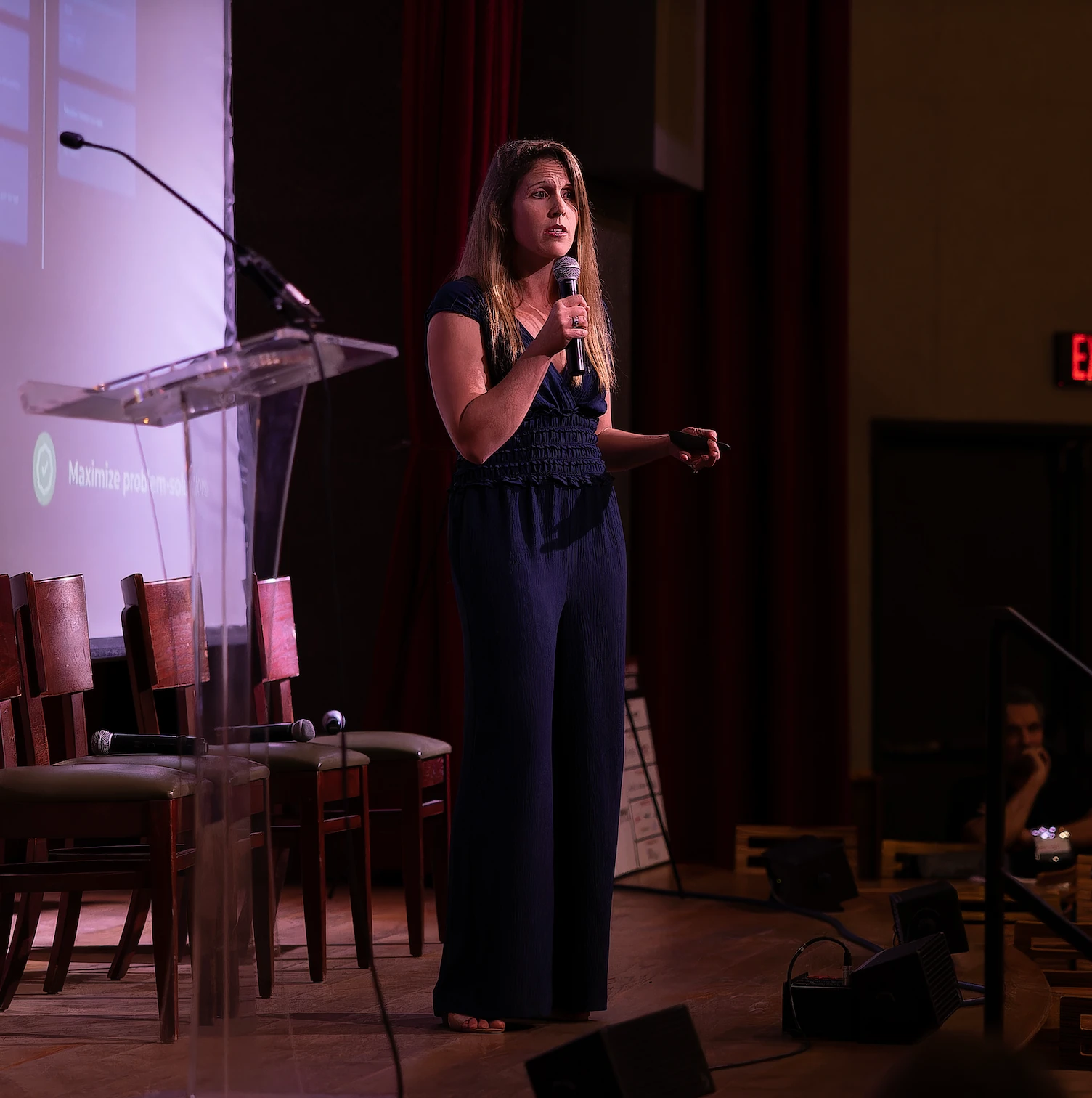 Maddie Bell on stage, speaking into a microphone
